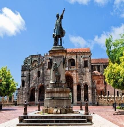 Estatua de Colón en una plaza de ladrillo frente a la fachada de piedra de la Catedral de Santo Domingo